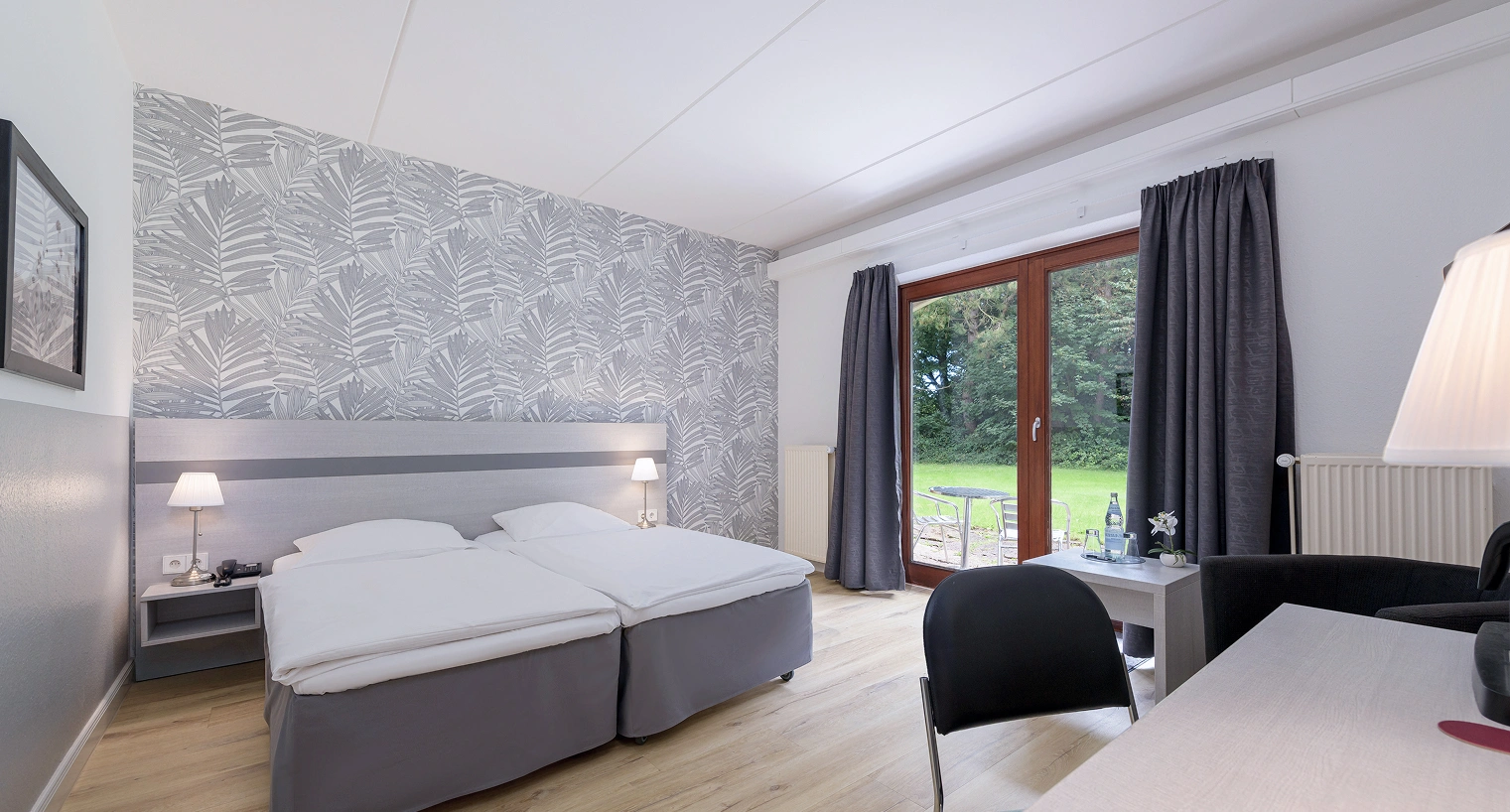 Doppelbett mit Schreibtisch und großem Fenster
